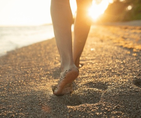 piedi in riva al mare al tramonto